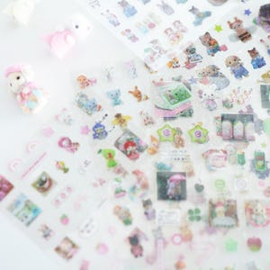 May include: A sheet of clear stickers featuring a range of colourful cartoon characters, animals, and objects. The stickers are ideal for adding a touch of whimsy to journals, planners, and other craft projects.