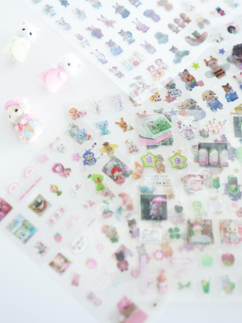 May include: A sheet of clear stickers featuring a range of colourful cartoon characters, animals, and objects. The stickers are ideal for adding a touch of whimsy to journals, planners, and other craft projects.