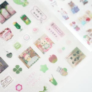 May include: A sheet of clear stickers with various designs, including animals, food, and plants. The stickers are on a white background. The stickers are in pink, green, and white.