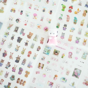 May include: A sheet of clear stickers featuring adorable cartoon animals, including bears, bunnies, cats, and more. The stickers are perfect for adding a touch of whimsy to planners, journals, and other craft projects.