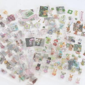 May include: A sheet of clear sticker paper with various colourful cartoon animal stickers. The stickers feature a variety of animals, including cats, dogs, rabbits, and birds. The stickers are perfect for adding a touch of whimsy to your planner, journal, or scrapbook.