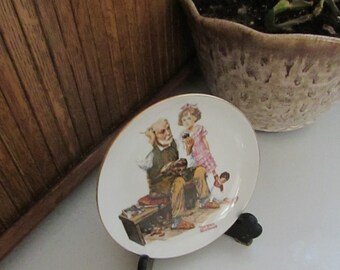 The Cobbler  Plate – 6 1/2” Norman Rockwell Plate – Girl Carrying Crate of Spaniel Puppies – Vintage Decorative Collectible Plate