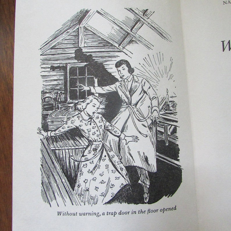 May include: A black and white illustration of two women in a room with a trap door opening in the floor. The woman in the foreground is wearing a dress with a floral pattern. The woman in the background is wearing a coat and is reaching towards the trap door.