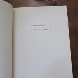 May include: A white book with the title "Crainquebille" and the text "Illustrated by Bernard Lamotte" on the cover.