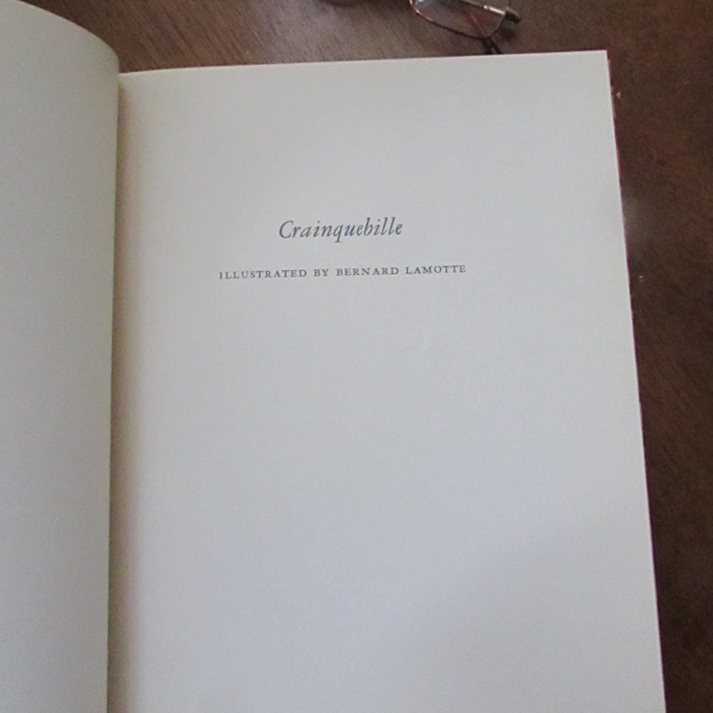 May include: A white book with the title "Crainquebille" and the text "Illustrated by Bernard Lamotte" on the cover.