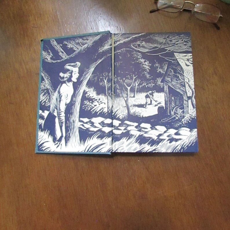 May include: An open book with a blue cover and white illustrations. The illustrations depict a woman standing in a forest and a man working in a garden.