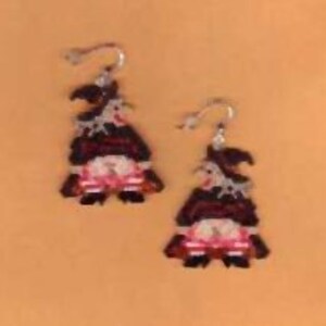 May include: A pair of silver dangle earrings featuring a witch with a black hat, red and black dress, and white stockings. The witch is holding a black bucket.