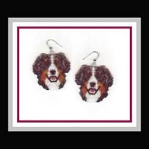 Peut inclure: Une paire de boucles d'oreilles représentant un visage de chien de montagne bernois, avec une fourrure brune, noire et blanche, et une expression joyeuse.