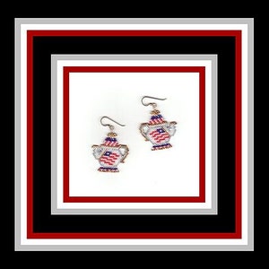 Può includere: Un paio di orecchini d'argento con un design a forma di teiera. La teiera è decorata con un motivo a bandiera americana in rosso, bianco e blu.