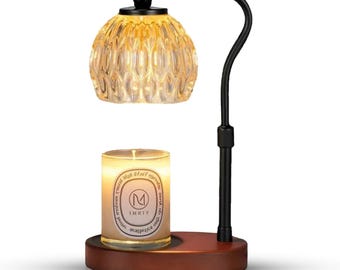 May include: A black metal candle warmer with a clear glass shade and a wooden base. The warmer has a candle holder and a light bulb. The candle is labeled "IMIXY" and has the text "Natural What Makes It Special" on the side.