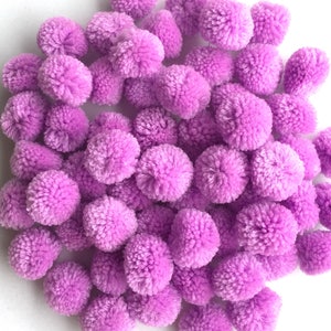 May include: A large pile of purple pom poms. The pom poms are made of soft, fluffy yarn and are perfect for crafting projects.
