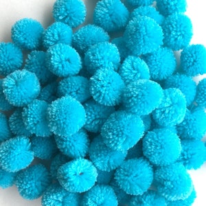 May include: A large group of bright turquoise pom poms. The pom poms are soft and fluffy, and they are perfect for adding a touch of colour and texture to any craft project.