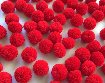 May include: A large group of red pom-poms arranged in a diagonal pattern on a white background.