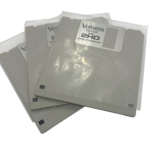 May include: A stack of gray 3.5-inch floppy disks in clear plastic packaging. The label on the front of the disk reads "Verbatim DataLife MF 2HD APPLE FORMAT". The disks are a light gray color.