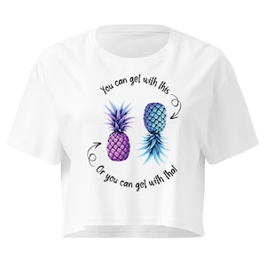 May include: A white crop top t-shirt featuring a graphic of two pineapples, one purple and one blue, with the text "You can get with this" above and "Or you can get with that" below, accompanied by two black hand-drawn arrows pointing to each fruit.
