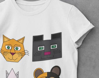 May include: White t-shirt featuring a graphic print of four stylised cat faces. The cats are orange, black, white, and orange and black.