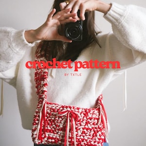 以下が含まれることがあります： 赤と白のかぎ針編みバッグ、長いストラップ付き。バッグは太い糸でできており、質感があります。「crochet pattern」の文字が画像全体に赤色で表示され、その下に「BY TXTLE」と書かれています。