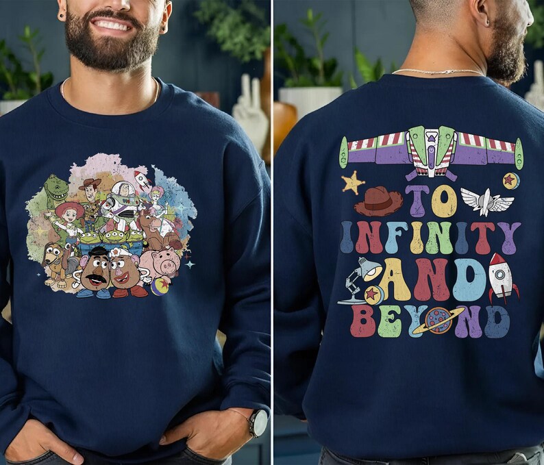 May include: Navy blue sweatshirt featuring a colorful graphic of Toy Story characters on the front. The back of the sweatshirt displays a Buzz Lightyear design with the phrase "To Infinity and Beyond" in a retro font.