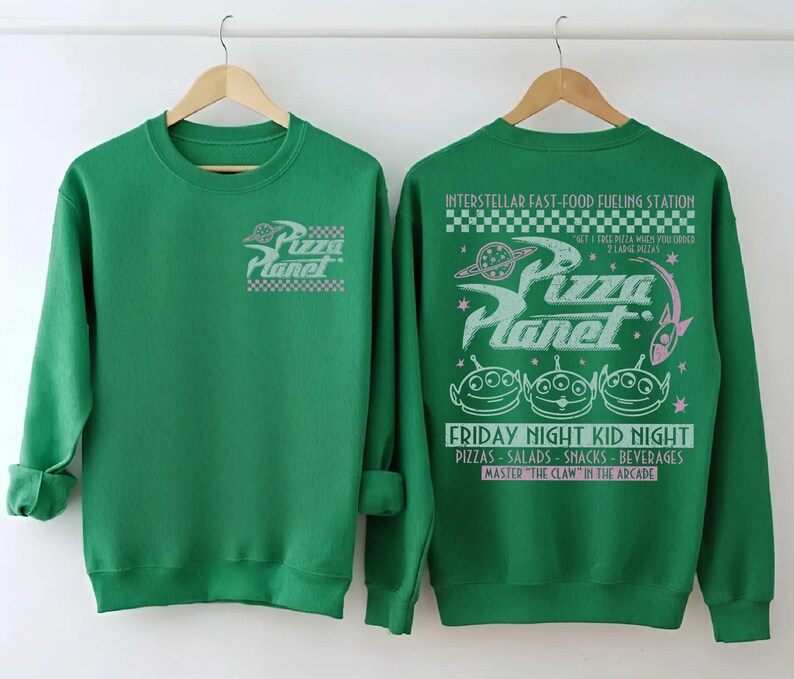 May include: Green sweatshirt featuring the Pizza Planet logo on the front and back. The back design includes the text "Interstellar Fast-Food Fueling Station" and "Friday Night Kid Night". The design also features three green alien characters.