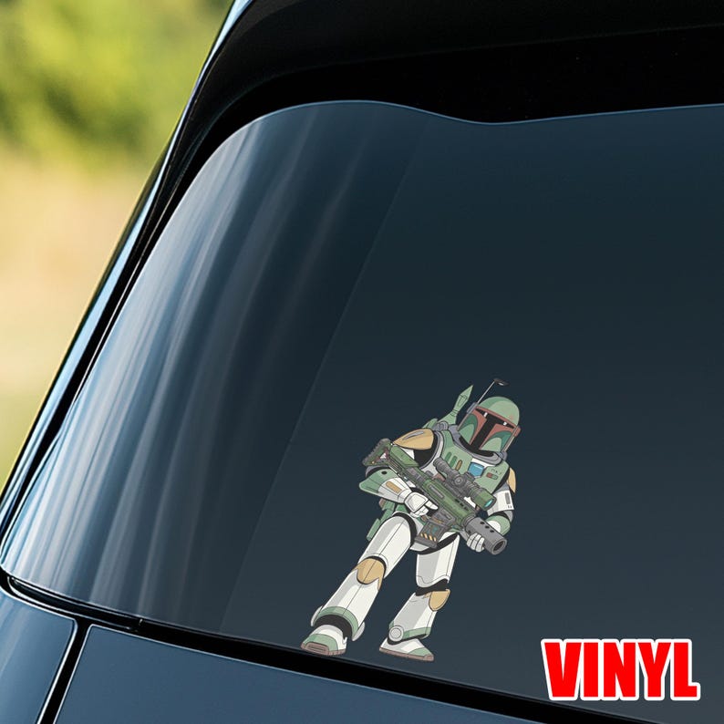 Puede incluir: Una calcoman&iacute;a de vinilo con una ilustraci&oacute;n de dibujos animados de un cazarrecompensas con armadura verde, blanca y gris, sosteniendo un rifle bl&aacute;ster. La palabra "VINYL" est&aacute; impresa en rojo.