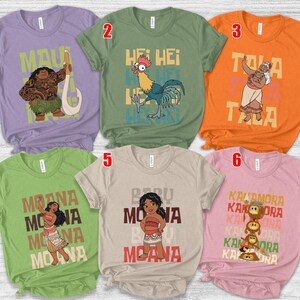 May include: Six short-sleeved t-shirts featuring characters and text from the animated film Moana. The shirts are in various colors, including purple, green, orange, and pink. Each shirt has a different design, with characters like Maui, Hei Hei, and Moana.