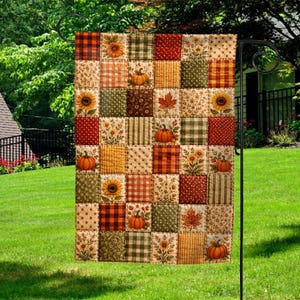 May include: A rectangular garden flag featuring a patchwork design of autumn-themed fabric squares. The pattern includes various prints of pumpkins, sunflowers, maple leaves, plaid, polka dots, and stars in shades of orange, brown, green, and red.