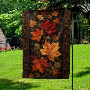 May include: A rectangular garden flag featuring a dark background with a vibrant pattern of autumn maple leaves in shades of red, orange, and gold. The central design is framed by ornate, scrolling decorative borders on the left and right sides.
