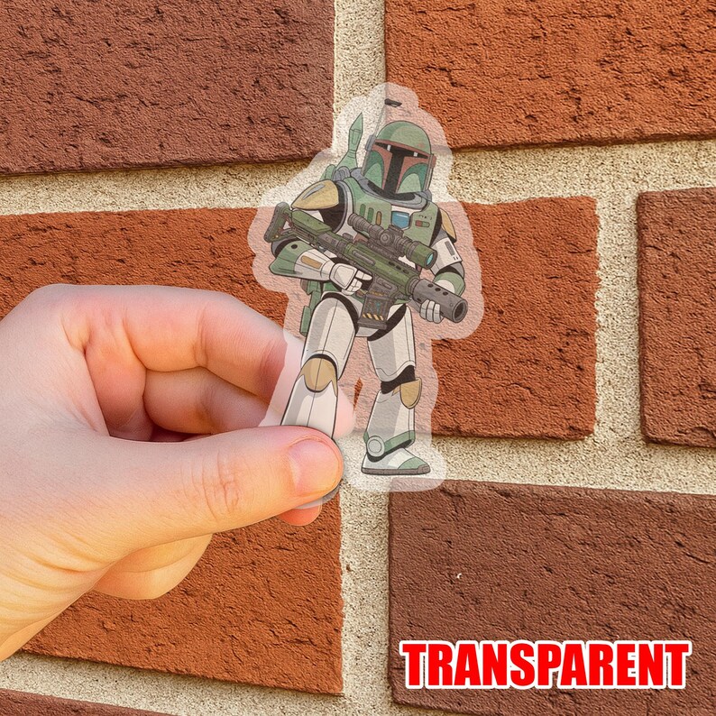 Puede incluir: Adhesivo transparente con una ilustraci&oacute;n de dibujos animados de un personaje con armadura verde y blanca, sosteniendo un rifle. El adhesivo tiene un fondo transparente y la palabra "TRANSPARENT" en rojo. El adhesivo se sostiene frente a una pared de ladrillos.