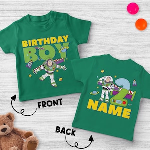 Pu&ograve; includere: T-shirt verdi con grafica di Buzz Lightyear. La parte anteriore della maglietta dice "BIRTHDAY BOY" in lettere gialle. La parte posteriore della maglietta ha il numero "2" e la parola "NAME" in giallo.