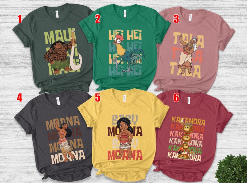 May include: Six short-sleeved t-shirts with character graphics and text from the animated film Moana. The shirts are in various colors, including green, yellow, and maroon. Each shirt features a different character and text.