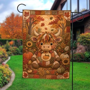 May include: A rectangular garden flag featuring a central illustration of a fluffy Highland cow with a patchwork-style body, surrounded by autumn leaves, sunflowers, and pumpkins in shades of orange, brown, and gold, set against a forest background.