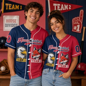 May include: A split-color baseball jersey featuring a navy blue side with an eagle graphic labeled Team 1 and a red side with a fox graphic labeled Team 2. The front displays the text House Divided in script, with white piping and black buttons.