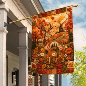May include: A rectangular garden flag featuring a patchwork-style illustration of a deer standing in an autumn forest. The scene includes a windmill, mushrooms, acorns, and colorful fall foliage in shades of orange, red, and gold.