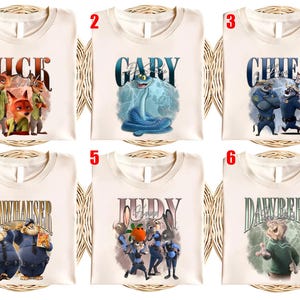 May include: Six cream-colored t-shirts with different character designs from the movie Zootopia. Each shirt features a character's name in a stylized font, along with a corresponding illustration of the character.