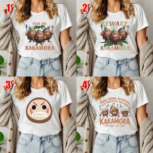 May include: White t-shirts with various Kakamora designs. One shirt says "FEAR THE KAKAMORA" with cartoon characters. Another says "BEWARE THE KAKAMORA". A third shirt has a Kakamora face. The last shirt says "TRIBAL DRUMS, BLOWGUNS, LEAF BRACELETS AND MORE KAKAMORA".