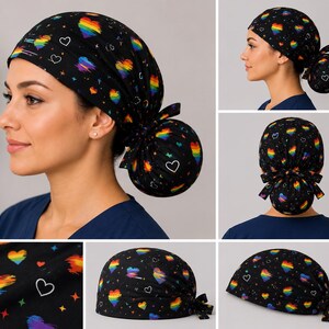 May include: A black scrub cap featuring a repeating pattern of rainbow-colored hearts and small white heart outlines. The fabric is decorated with tiny colorful stars scattered across the black background. The cap includes a tie-back closure.