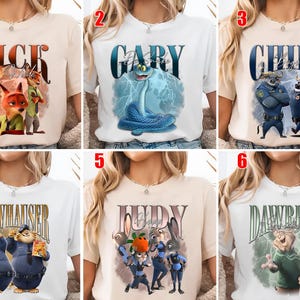 May include: A collection of six t-shirts featuring characters from the animated movie "Zootopia." Each shirt displays a character's name in a stylized font, accompanied by a graphic of the character. The shirts are in various colors, including white and beige.
