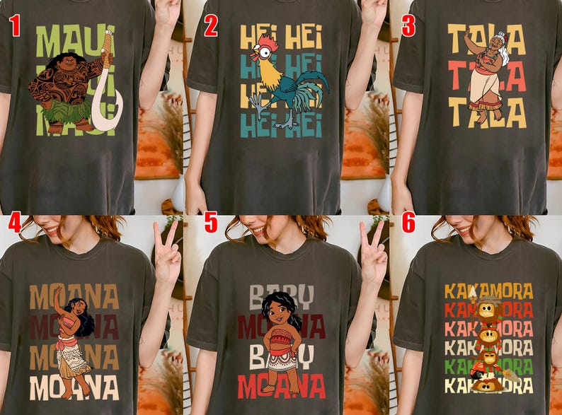 May include: Dark gray t-shirts featuring characters and text from a popular animated film. Designs include Maui, Hei Hei, Tala, Moana, Baby Moana, and the Kakamora. Each shirt has a unique graphic and text.