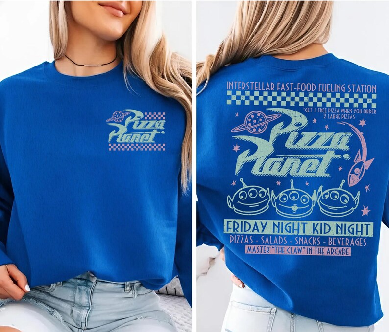 May include: Royal blue sweatshirt featuring the Pizza Planet logo on the front and back. The back design includes the text "Interstellar Fast-Food Fueling Station" and "Friday Night Kid Night". The design also features three green alien characters.