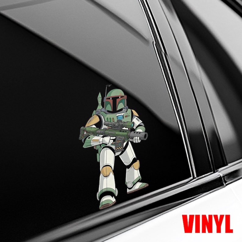 Puede incluir: Una calcoman&iacute;a de vinilo con una ilustraci&oacute;n de dibujos animados de un personaje con una armadura verde y blanca, sosteniendo un rifle. El personaje est&aacute; sobre una superficie negra, con la palabra "VINYL" en rojo en la parte inferior.