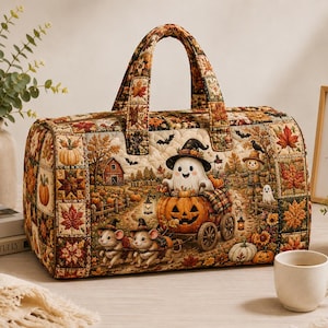May include: A quilted duffel bag featuring a festive autumn scene with a ghost in a pumpkin carriage pulled by two mice. The fabric displays a patchwork pattern of fall leaves, pumpkins, and bats in warm orange, brown, and green tones.