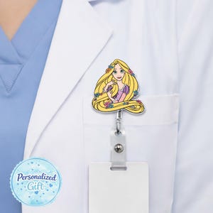 May include: A badge reel featuring a cartoon image of a princess with long blonde hair, wearing a pink and purple dress, and adorned with flowers. The reel is attached to a white pocket. The text "Personalized Gift" is on a blue background.