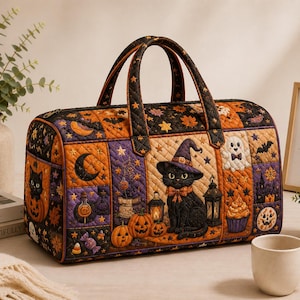 May include: A quilted duffel bag featuring a Halloween-themed print with a black cat wearing a witch hat, pumpkins, ghosts, bats, and autumn leaves in shades of orange, purple, and black. The bag has two top handles and a zippered closure.