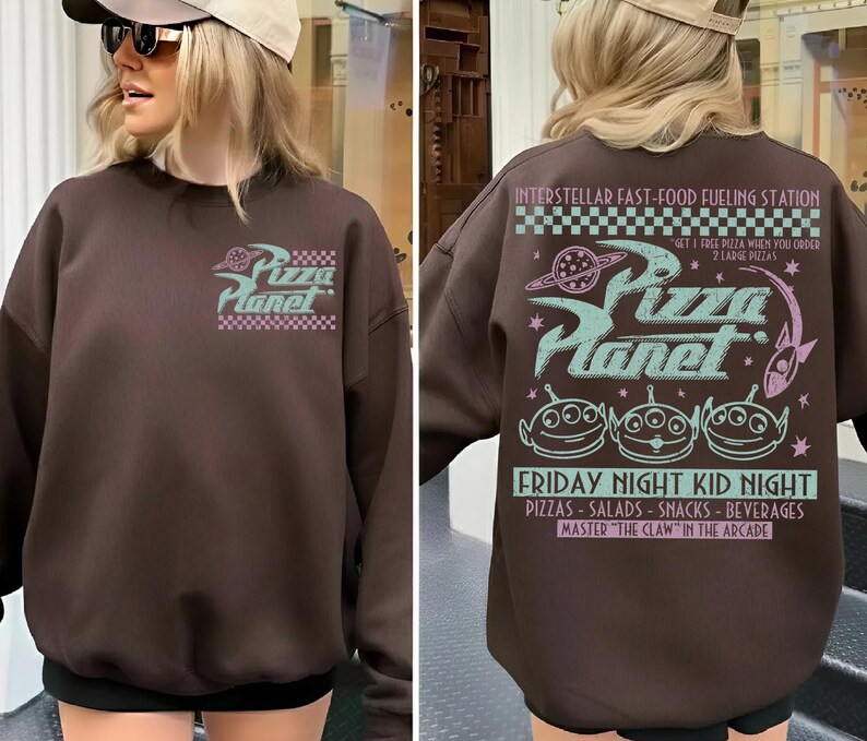 May include: A brown sweatshirt with the Pizza Planet logo on the front and back. The front logo is a stylized design with the words "Pizza Planet" in a retro font. The back features the text "Interstellar Fast-Food Fueling Station" and "Friday Night Kid Night".