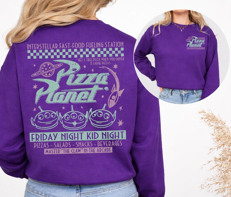 May include: A purple sweatshirt featuring the Pizza Planet logo and alien characters. The back of the sweatshirt has the text "INTERSTELLAR FAST-FOOD FUELING STATION" and "FRIDAY NIGHT KID NIGHT". The front has the Pizza Planet logo.
