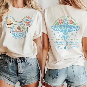 May include: Cream-colored t-shirt with a Mickey Mouse-shaped design featuring a boat, palm trees, and the text "COME WHAT MAY I KNOW THE WAY." The back of the shirt displays a blue manta ray design with the text "THERE IS NOWHERE YOU CAN GO THAT I WON'T BE WITH YOU."