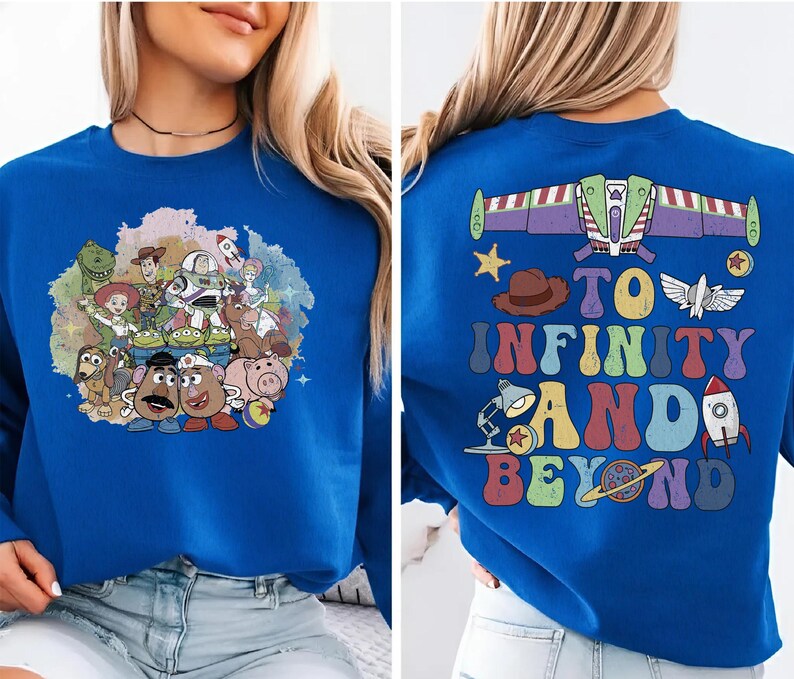 May include: Royal blue sweatshirt featuring a colorful graphic of Toy Story characters on the front. The back of the sweatshirt displays a Buzz Lightyear design with the phrase "To Infinity and Beyond" in a retro font.