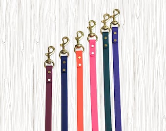 Peut inclure: Six laisses pour chiens de couleurs vives. Chaque laisse présente une couleur différente : bordeaux, bleu marine, orange, rose, vert foncé et violet. Elles sont équipées de mousquetons dorés et de rivets assortis.
