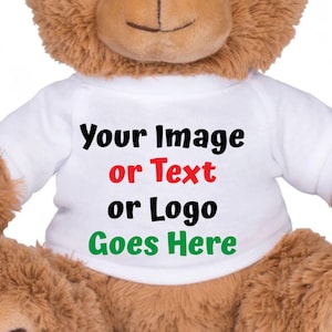 May include: A brown teddy bear wearing a white t-shirt. The t-shirt has the text "Your Image or Text or Logo Goes Here" in black, red, and green. The bear has a soft, plush appearance.