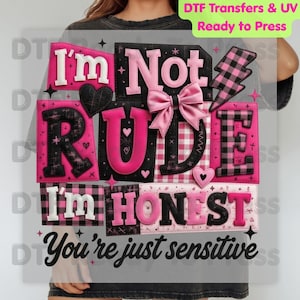 May include: A ready-to-press DTF transfer featuring the text "I'm Not Rude I'm Honest, You're just sensitive." The design includes pink and black letters, hearts, a bow, and a plaid lightning bolt. The transfer is for UV printing.